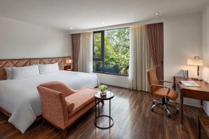 een hotelkamer met een bed, een bureau en een stoel bij Ravatel Home Bac Giang in Bắc Giang