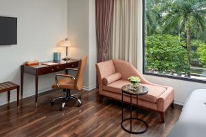 una camera d'albergo con scrivania, sedia e scrivania. di Ravatel Home Bac Giang a Bắc Giang
