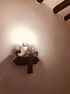 ein Licht an einer Wand mit einem Kreuz darauf in der Unterkunft MEA CASA Toscana in Castellina in Chianti