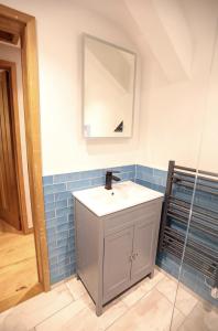 a bathroom with a sink and a mirror at Cobble Cottage in St Just