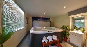 duża łazienka z wanną i oknem w obiekcie Gîte Lilas, LOFT 2 à 8 personnes, avec salle de jeux et SPA dans la résidence w mieście Ventron