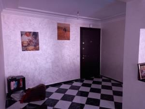 Habitación con suelo a cuadros y puerta negra en APPARTEMENT ZENITH, en Casablanca