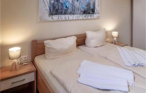 a bedroom with two beds with white sheets and two lamps at Beautiful Home In Gützkow With Kitchen in Gützkow +12 photos