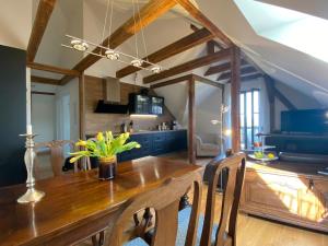 cocina y comedor con mesa de madera y sillas en Altes Pfarrhaus en Papstdorf