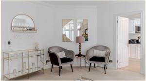 2 sillas en una habitación con mesa y espejo en Maddox House, en Londres