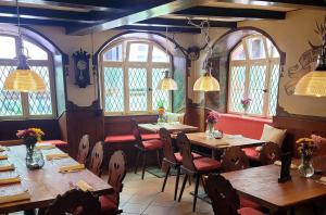 a restaurant with wooden tables and chairs and windows at Appartement Altstadt, Gasthaus Hirsch in Hirschhorn