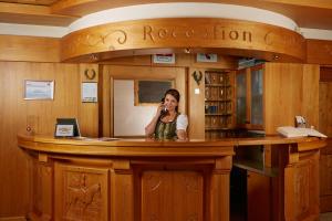 a woman talking on a cell phone at a bar at SALZANO Hotel - Spa - Restaurant in Interlaken