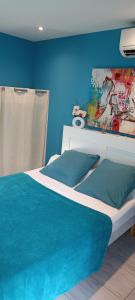 Schlafzimmer mit einem Bett mit blauer Wand in der Unterkunft Bedroom Agde 34300 in Agde