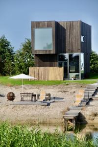 a building on the beach with chairs and an umbrella at Svenceles Namai in Svenele