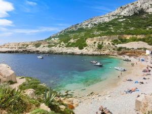 a beach with people and boats in the water at Ibis Budget Marseille Est Porte d'Aubagne in Marseille