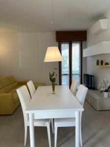 einen weißen Tisch und Stühle im Wohnzimmer in der Unterkunft Il Timone in Toscolano-Maderno