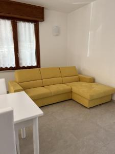 ein Wohnzimmer mit einem gelben Sofa in einem Zimmer in der Unterkunft Il Timone in Toscolano-Maderno