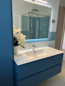 ein Badezimmer mit einem blauen Waschbecken und einem Spiegel in der Unterkunft Il Timone in Toscolano-Maderno
