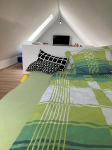 a bedroom with a green and white bed with pillows at Herzhof Lampert in Riegersburg
