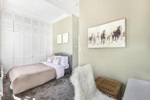 - une chambre avec un lit et un chien dans l'établissement Lovely large 1 bed renovated flat w balcony & 600MB WiFi, à Londres