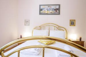 a bedroom with a bed with a gold frame at Gold n Blu Petalidi in Petalidhion