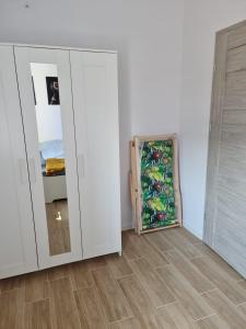 a room with a white cabinet and a mirror at Apartamenty "Aga" Rusinowo in Rusinowo