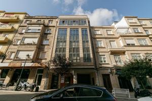 a car parked in front of a large building at PREMIUM HOME EL CORTE INGLES-parking in Vigo