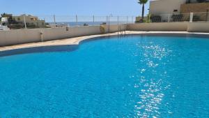 a large blue swimming pool next to a building at TRIPLEX DE LUJO EN MOJACAR in Mojácar
