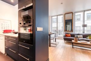 een keuken en een woonkamer met een blauwe muur bij Gorgeous 2 Bdrs Flat in a Prime Location - Opera in Parijs