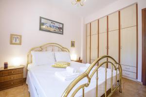 a bedroom with a white bed and a wooden cabinet at Gold n Blu Petalidi in Petalidhion