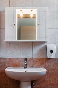 um lavatório de casa de banho com um armário branco e um espelho em F.D.STUDIOS em Lardos