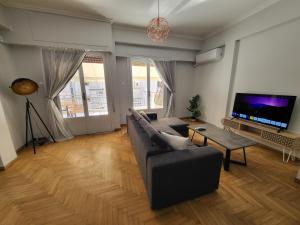 een woonkamer met een bank en een tv bij Maria's Maisonette in Athene