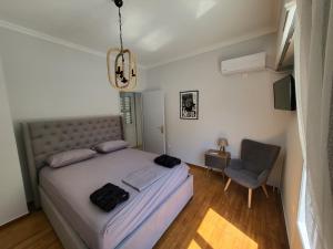 een slaapkamer met een groot bed en een stoel bij Maria's Maisonette in Athene