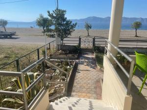 eine Treppe hinunter zu einem Strand mit einem Baum in der Unterkunft Atelié Yiouli in Pefki