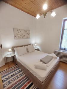 1 dormitorio con 1 cama blanca grande con alfombra en 1935 home en Lílaia