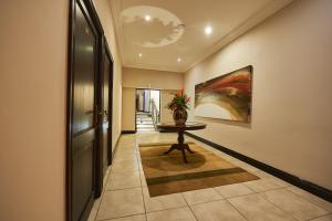 un couloir avec une table et un tableau sur le mur dans l'établissement Ebandla Hotel & Conference Centre, à Ballito