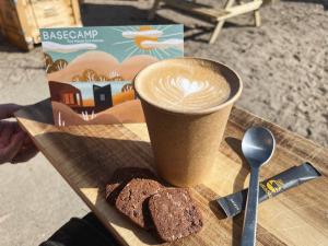 a cup of coffee and some bread on a table at Basecamp Tiny House Eco Resort in IJmuiden