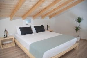 um quarto com uma grande cama branca e tectos em madeira em Agiopetra Lofts em Kavala