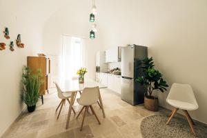 a kitchen with a table and chairs and a refrigerator at HelloApulia - La Terrazza di Don Nino in Polignano a Mare +13 photos
