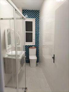 ein Bad mit einem WC, einem Waschbecken und einem Fenster in der Unterkunft Piso completo a 5 minutos del metro linea 5 verde in Madrid