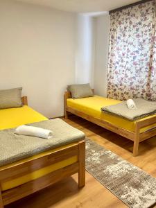 two beds in a room with yellow beds at Apartment SunLight in Visoko