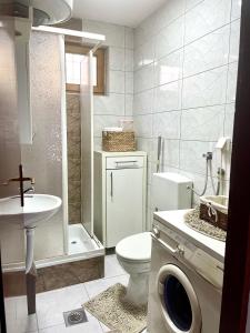 a bathroom with a toilet and a sink and a shower at Apartment SunLight in Visoko