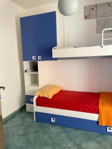 - une chambre avec des lits superposés avec des draps bleus et rouges dans l'établissement VillApulia, à Brindisi