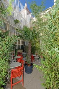 a patio with red chairs and tables and trees at Boutique Hostel Forum in Zadar