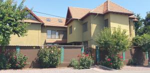 a house with a fence and flowers in front of it at Villa Mugur in 2 Mai