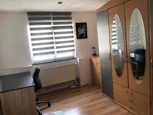 Zimmer mit einem Schreibtisch, einem Spiegel und einem Fenster in der Unterkunft Seven‘S Apartments I in Löhnberg