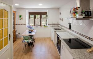 a kitchen with white cabinets and a table in it at Awesome Home In Brcena De Ebro With Kitchen in Bárcena de Ebro