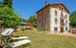 an external view of a stone house with chairs in the yard at Awesome Home In Brcena De Ebro With Kitchen in Bárcena de Ebro