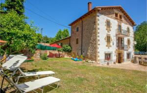 una vista exterior de una casa de piedra con sillas en el patio en Awesome Home In Brcena De Ebro With 4 Bedrooms, en Bárcena de Ebro