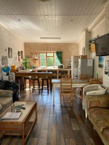 ein Wohnzimmer mit einem Tisch und einer Küche in der Unterkunft Barrys Guesthouse in Witsand