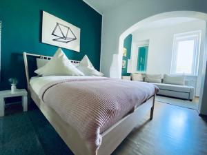 a blue bedroom with a bed and a couch at Villa Geisenhof in Miltenberg