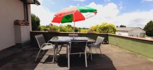 een tafel en stoelen met een parasol op een dak bij Appartement studio avec terrasse privatisée in Marmande