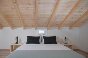 um quarto com uma cama grande e tectos em madeira em Agiopetra Lofts em Kavala