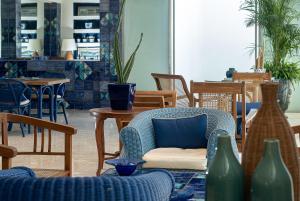uma sala cheia de cadeiras e mesas com vasos em Hotel Conca Park em Sorrento