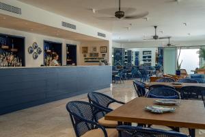 um restaurante com mesas e cadeiras e um bar em Hotel Conca Park em Sorrento